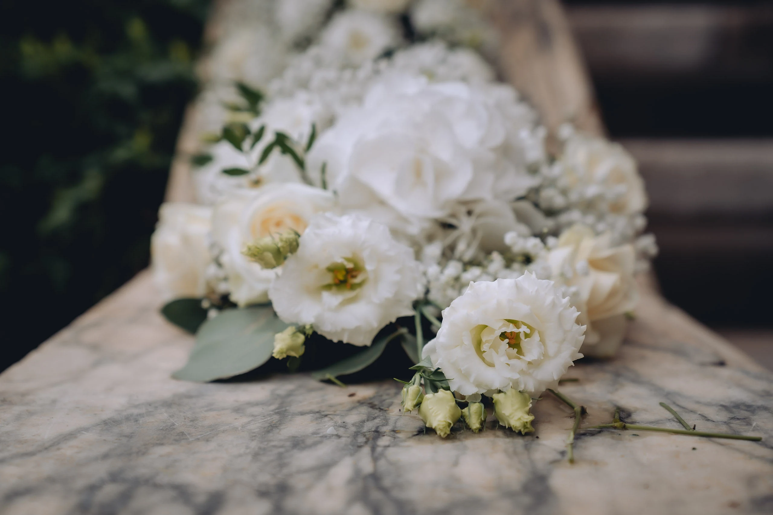 Bouquet di fiori bianchi appoggiato su una balaustra in marmo