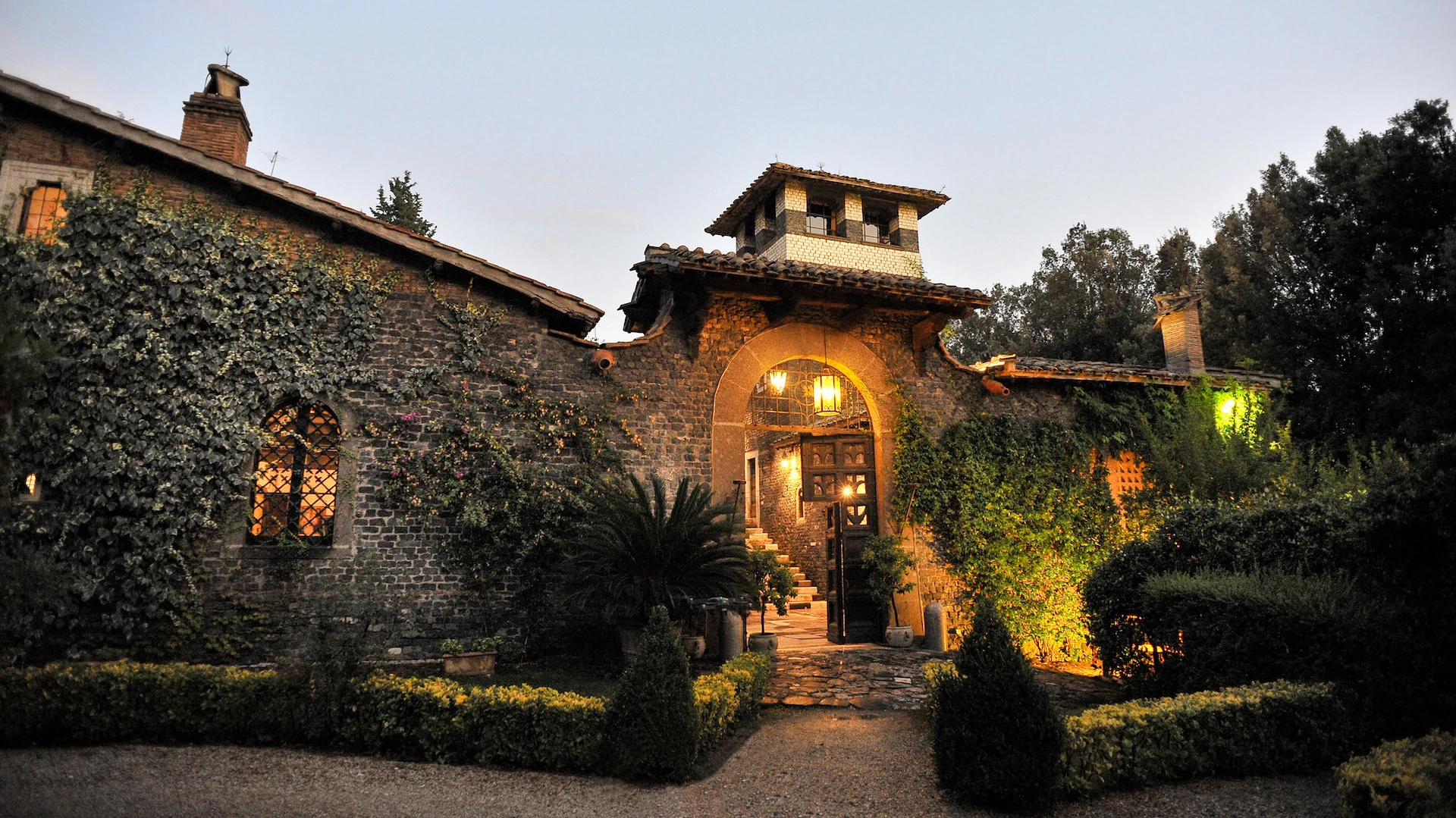 Ingresso ad arco e facciata in pietra del Castello della Spizzichina al crepuscolo